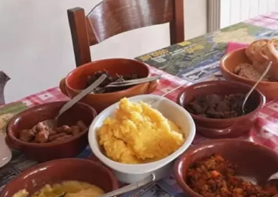 Tavola imbandita con polenta e carni cucinate al rifugio il dosso
